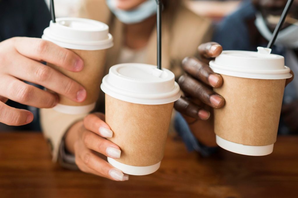 hands holding custom printed disposable coffee cups