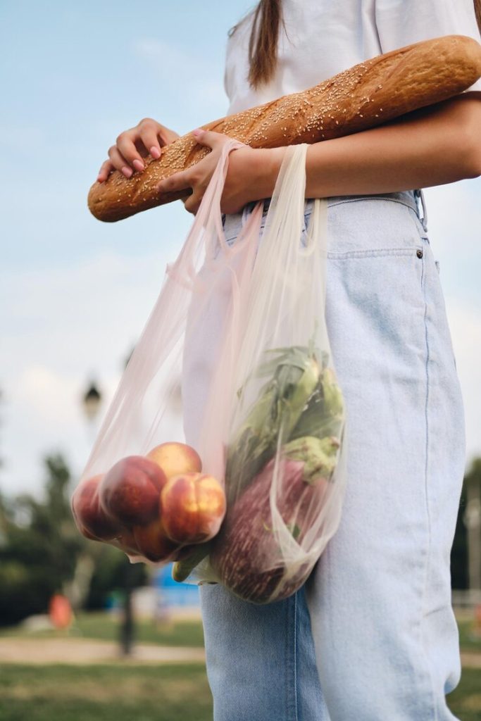 Woman carrying groceries in eco-friendly reusable bags for retail packaging