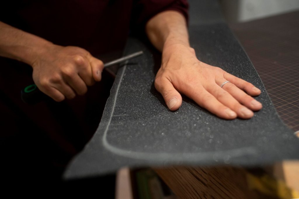 close-up of a hand cutting textured grip material
