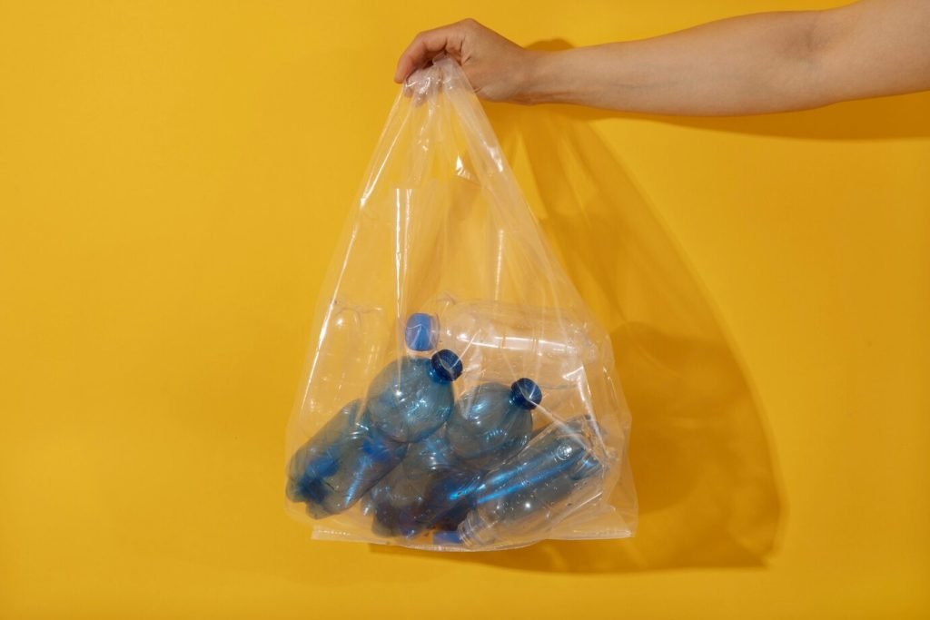 Hand holding a clear polyethylene bag containing bottled products