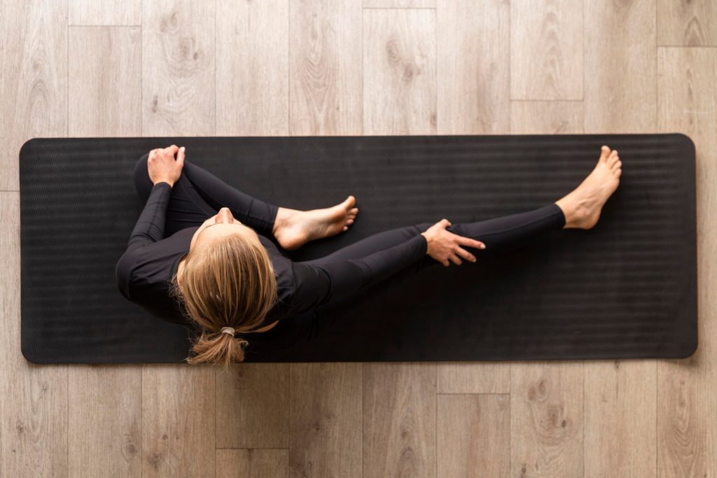 Woman practicing yoga on a mat outdoors