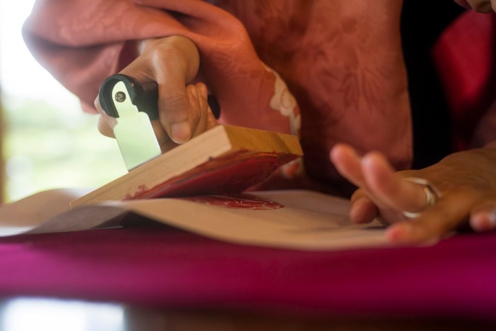 hands stamping a custom pattern onto colorful material