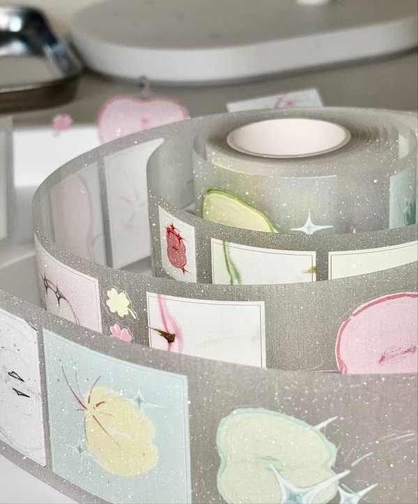 Roll of translucent decorative tape with pastel floral and fruit designs