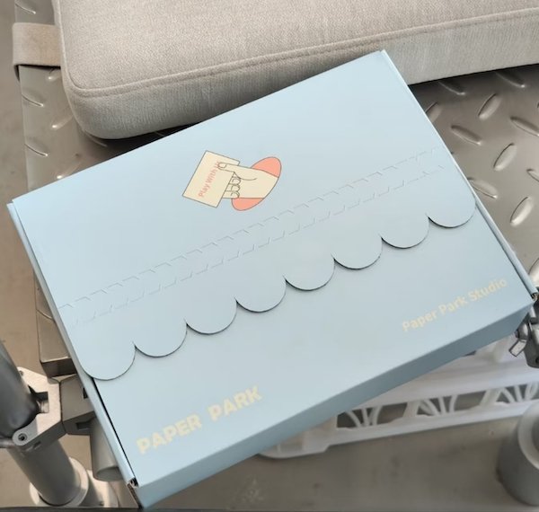Light blue box with scalloped edges, labeled "Paper Park Studio"