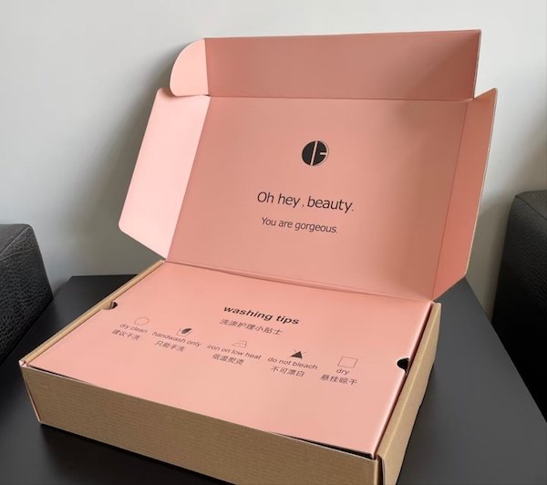 Open pink box with "Oh hey, beauty. You are gorgeous" text and washing tips