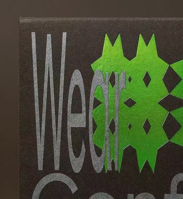 Dark packaging with bold green geometric design and modern silver typography
