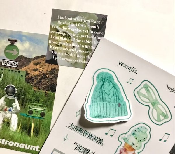 Collage featuring stickers, a postcard, and text with artistic elements