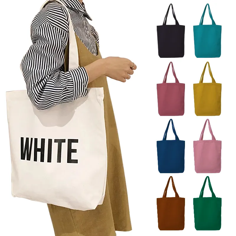 Person holding a white tote bag with colorful tote bags displayed on the side