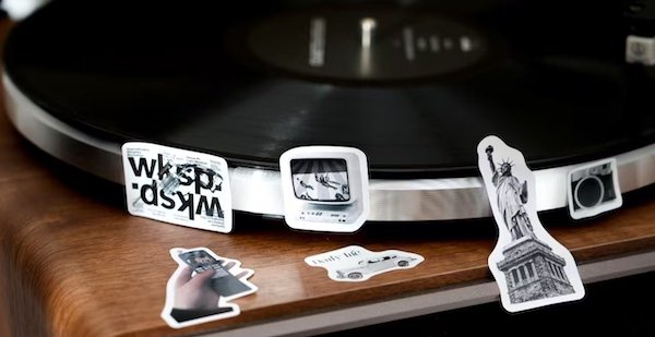Vinyl record player with vintage-themed stickers on the edge