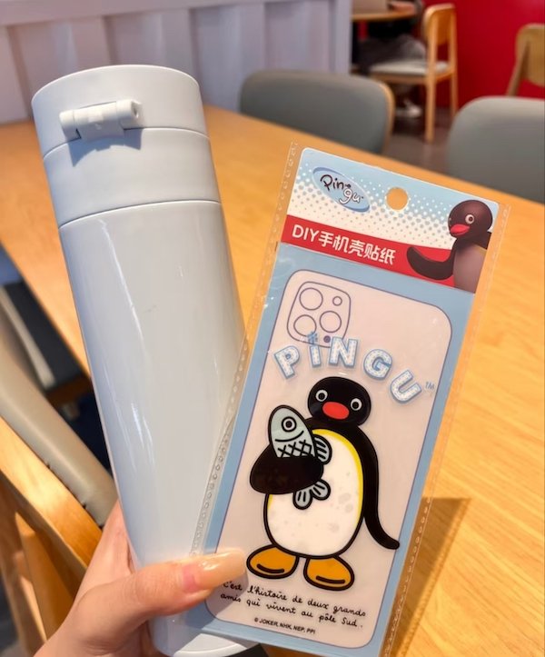 White thermos and Pingu-themed DIY phone sticker featuring a penguin holding a fish