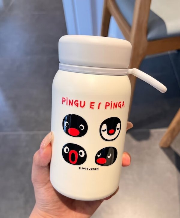 White bottle featuring cartoon penguin faces with various expressions