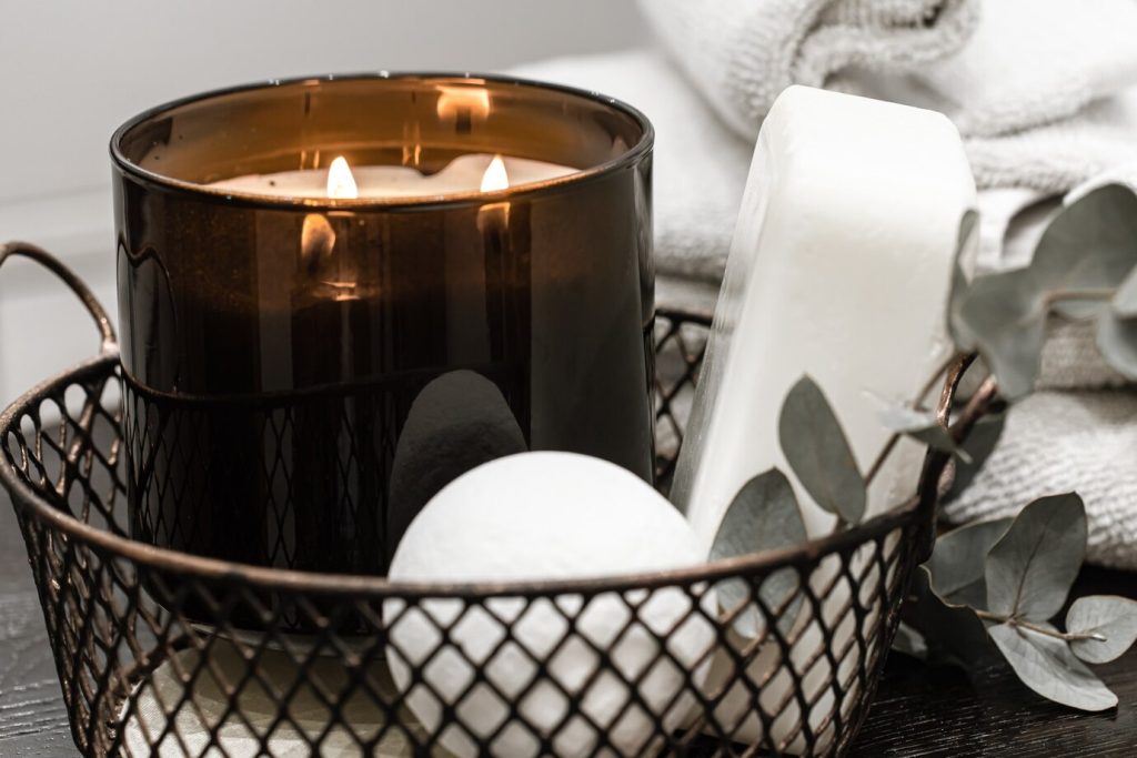burning candle displayed among bath and body care accessories