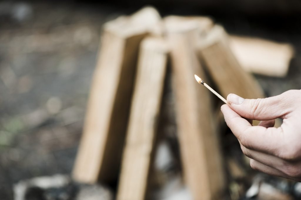 Close-up of a burning match illustrating candle wick flame