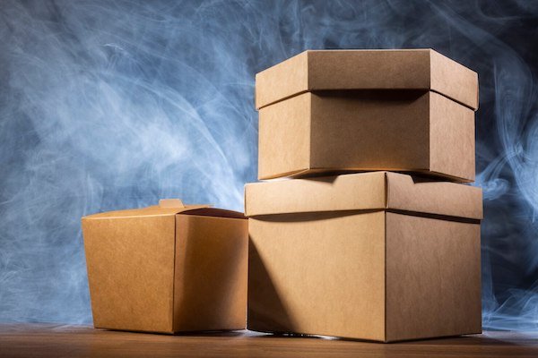 Stacked brown paper boxes with a smoky background and warm lighting