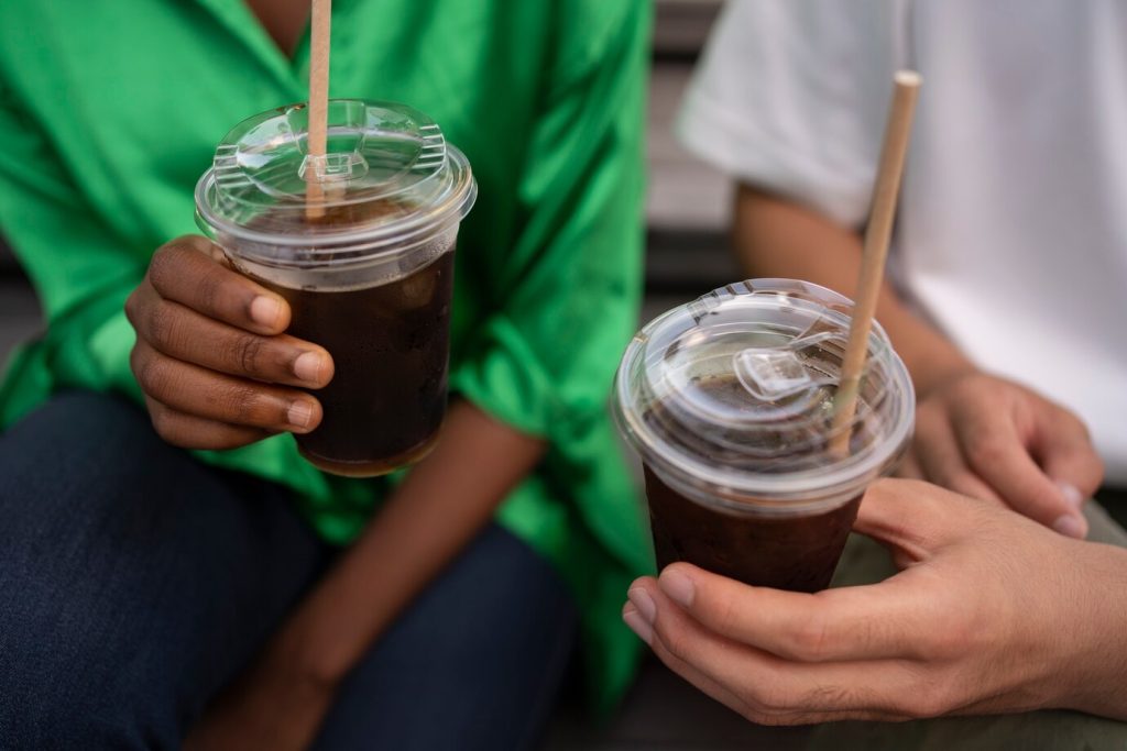 Friends enjoying iced coffee in disposable plastic cups