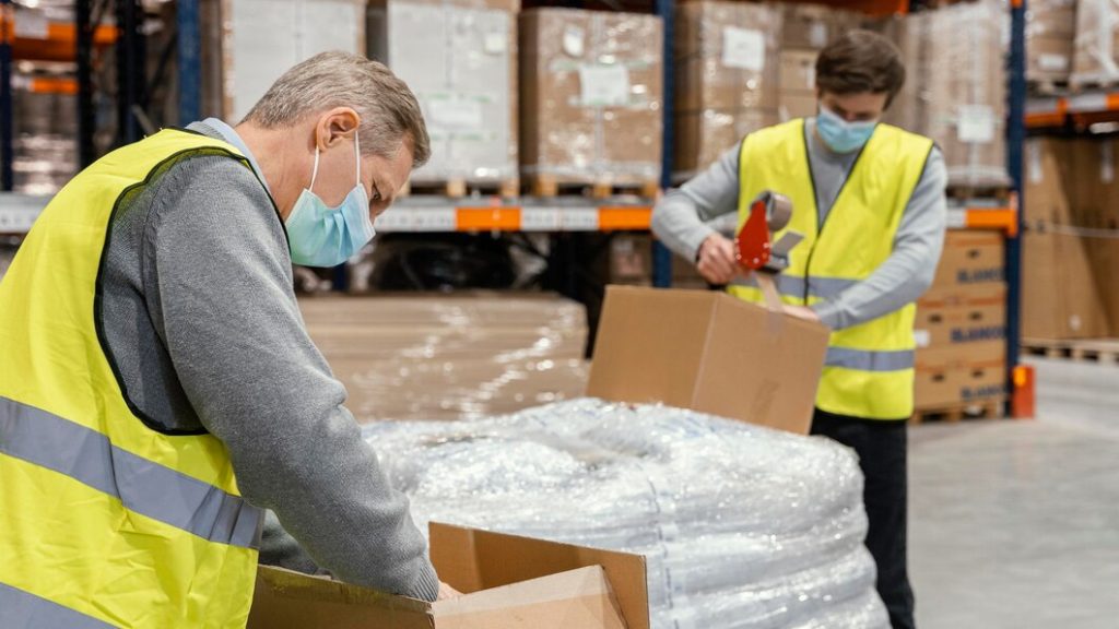 Warehouse workers handling packaged goods for export shipment