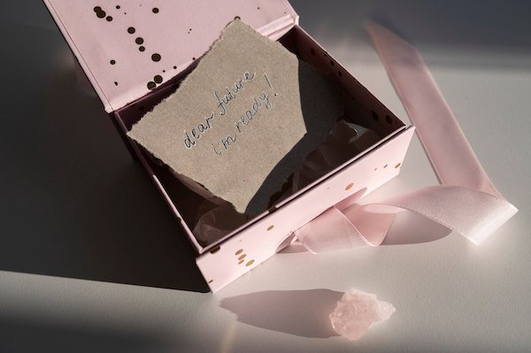 Pink gift box with ribbon, note reading "dear future, I'm ready!" inside