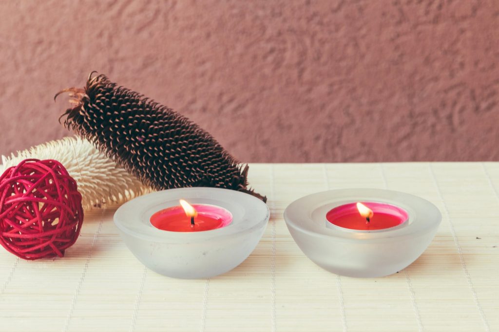 Pink candles displayed near a decorative red ornament