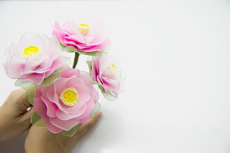 Hand holding pink artificial flowers
