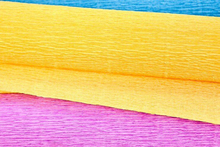 Rolled colorful crepe paper in yellow, pink, and blue shades