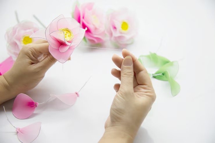 Hands crafting pink mesh flower