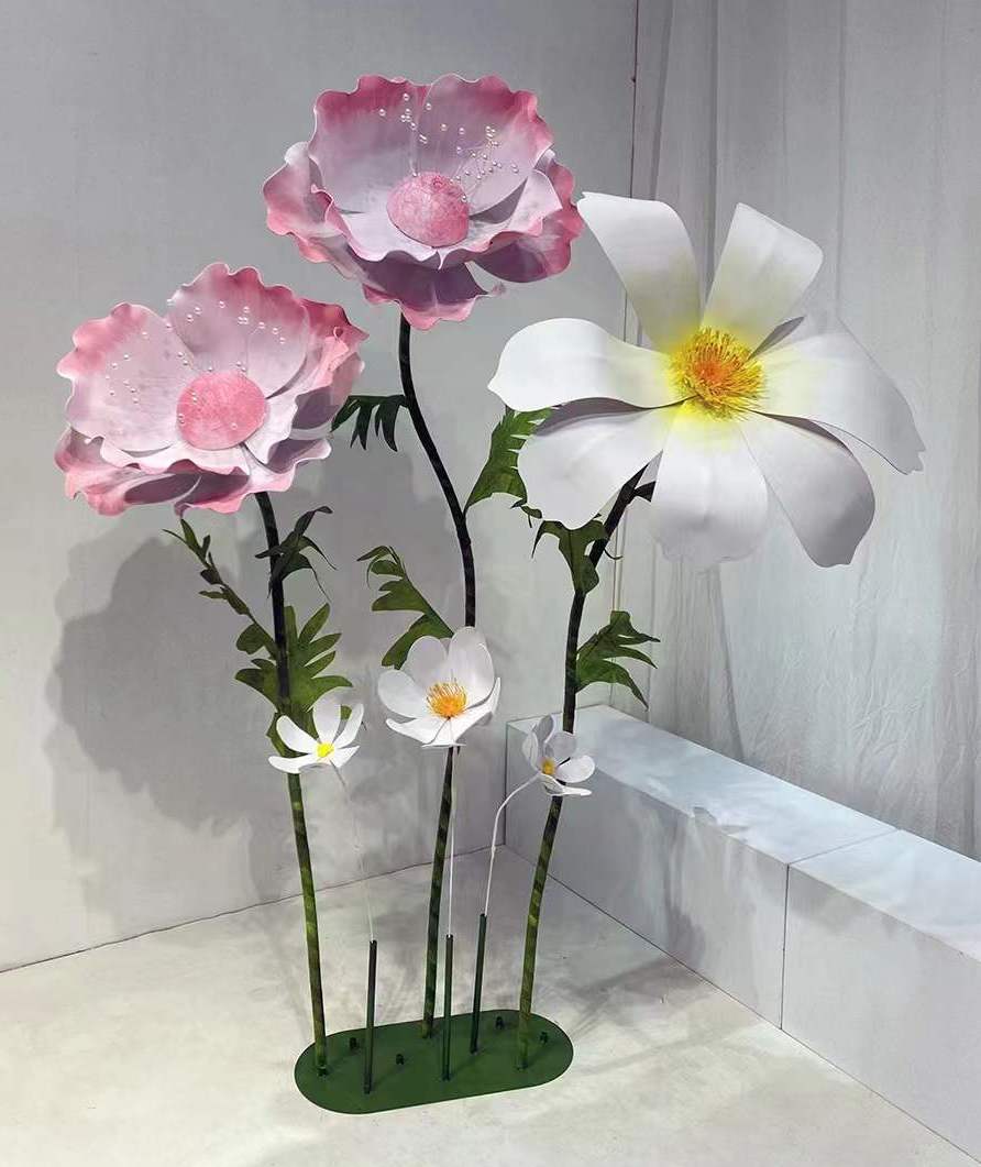 Large pink and white paper flowers with realistic details in an artistic setting