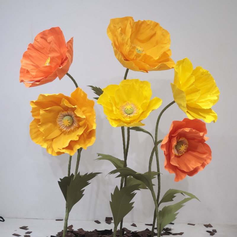 Bright yellow and orange paper poppies in a group display
