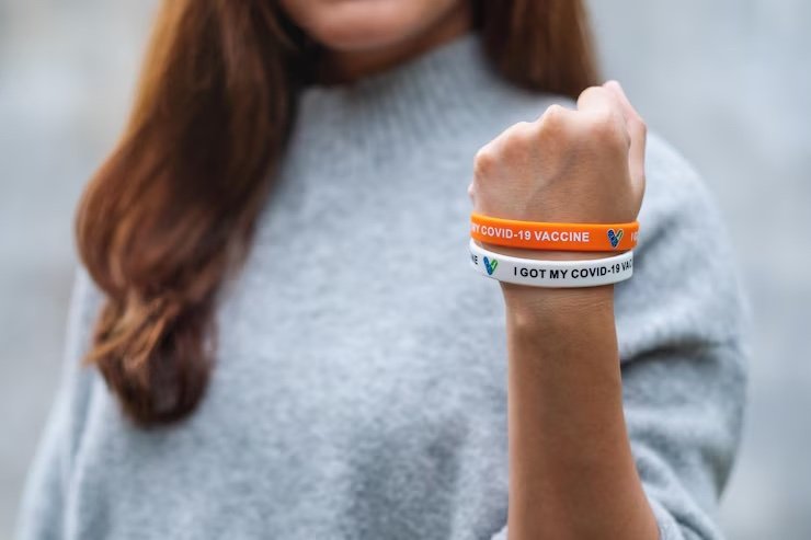 person wearing covid vaccination wristbands