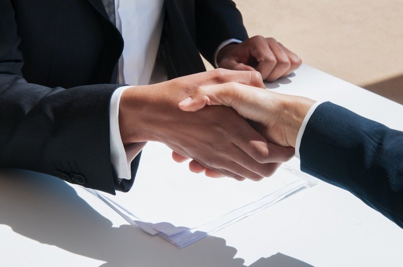 Two business people shaking hands to close a deal