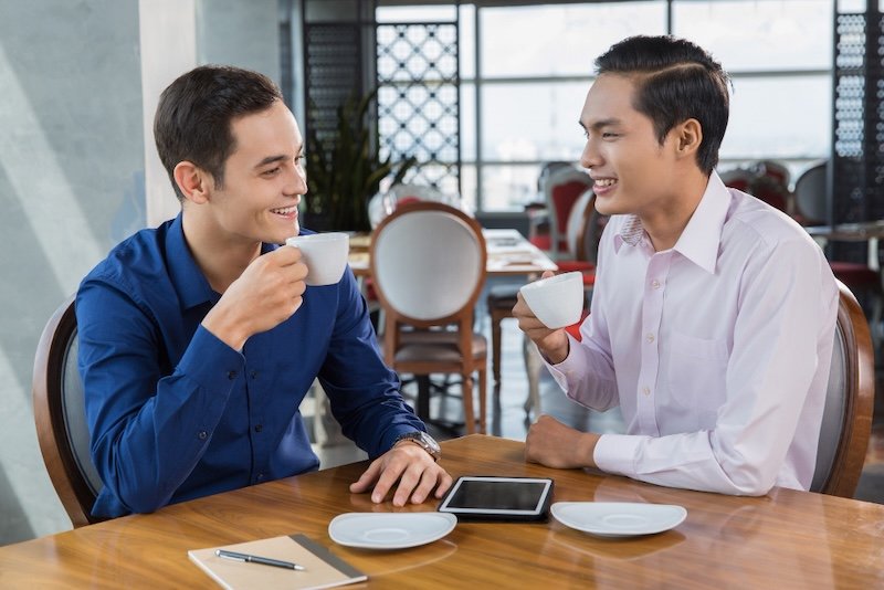 Two businessmen drinking coffee during a supplier meeting