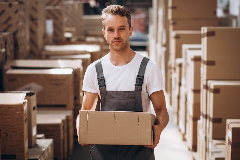 Young man working in a warehouse surrounded by boxes