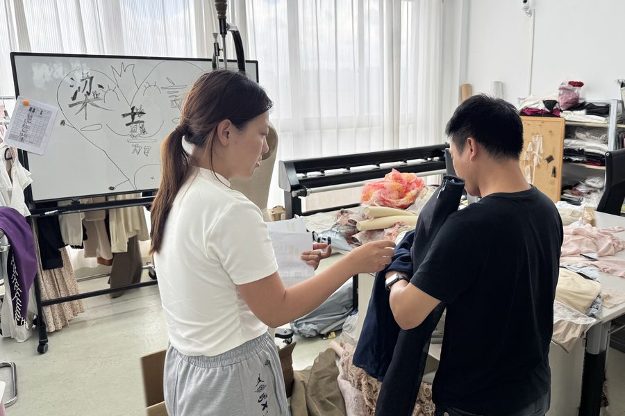 Mangors sourcing agent checking a garment sample with a supplier in the workshop